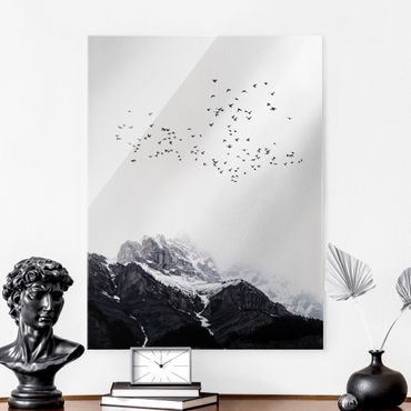 Glasbild - Vogelschwarm vor Bergen Schwarz Weiß - Hochformat 3:4