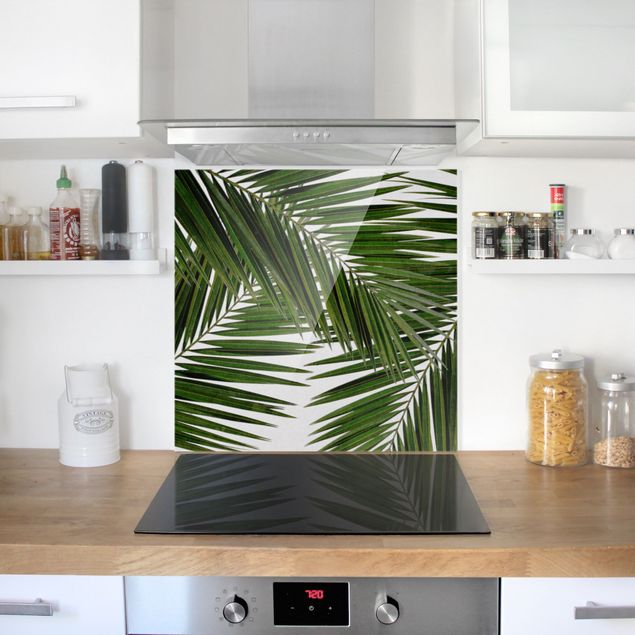 Küchenrückwand Glas Motiv Blumen Blick durch grüne Palmenblätter