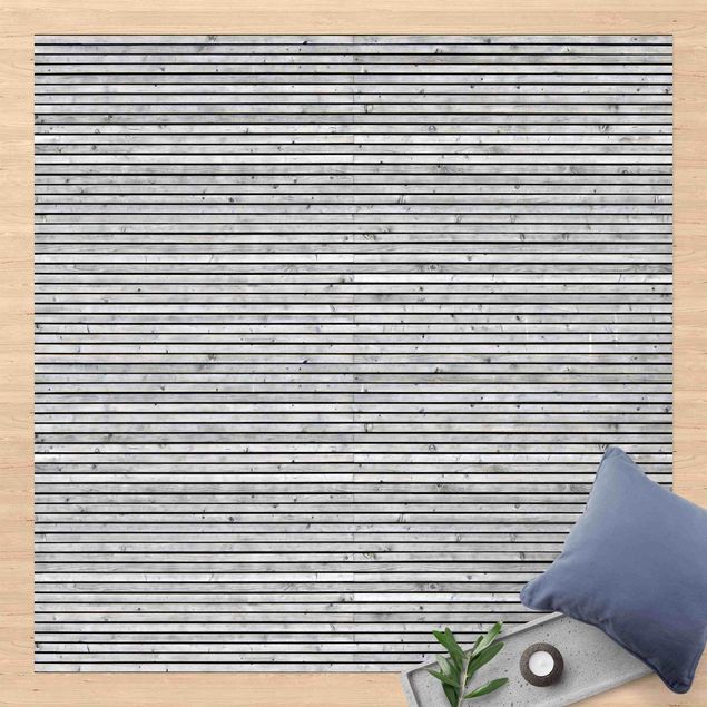 Aussen Teppich Holzwand mit schmalen Leisten schwarz weiß