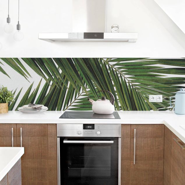 Küchenrückwand Glas Motiv Blumen Blick durch grüne Palmenblätter