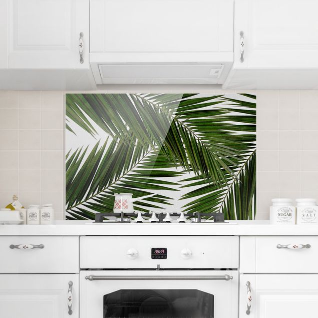 Küchenrückwand Glas Blumen Blick durch grüne Palmenblätter