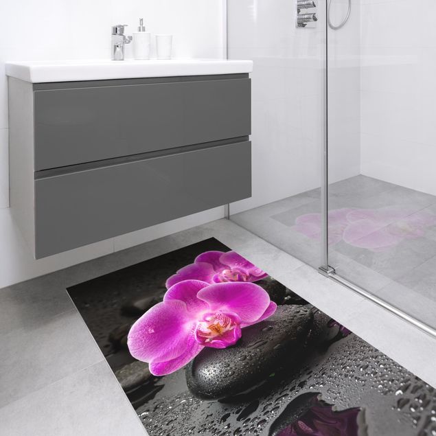 Teppiche Pinke Orchideenblüten auf Steinen mit Tropfen