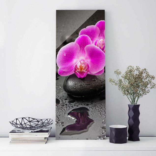 Glasbild Orchidee Pinke Orchideenblüten auf Steinen mit Tropfen