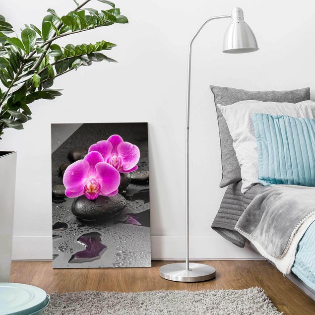 Glasbilder Pflanzen Pinke Orchideenblüten auf Steinen mit Tropfen
