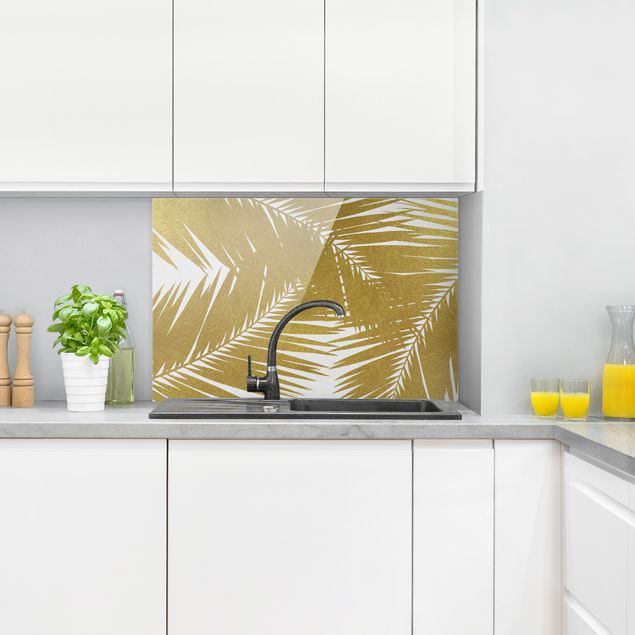 Küchenrückwand Glas Motiv Blumen Blick durch goldene Palmenblätter