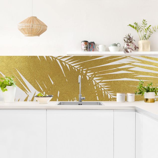 Küchenrückwand Glas Blumen Blick durch goldene Palmenblätter