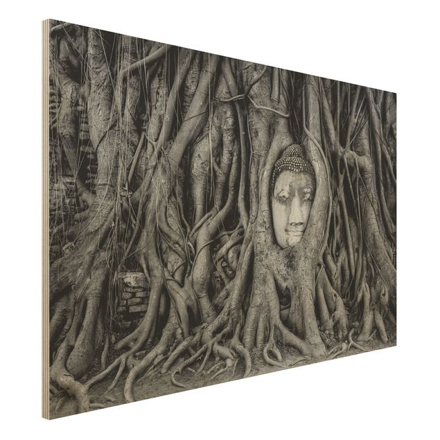 Holzbilder mit Blumen Buddha in Ayutthaya von Baumwurzeln gesäumt in Schwarzweiß